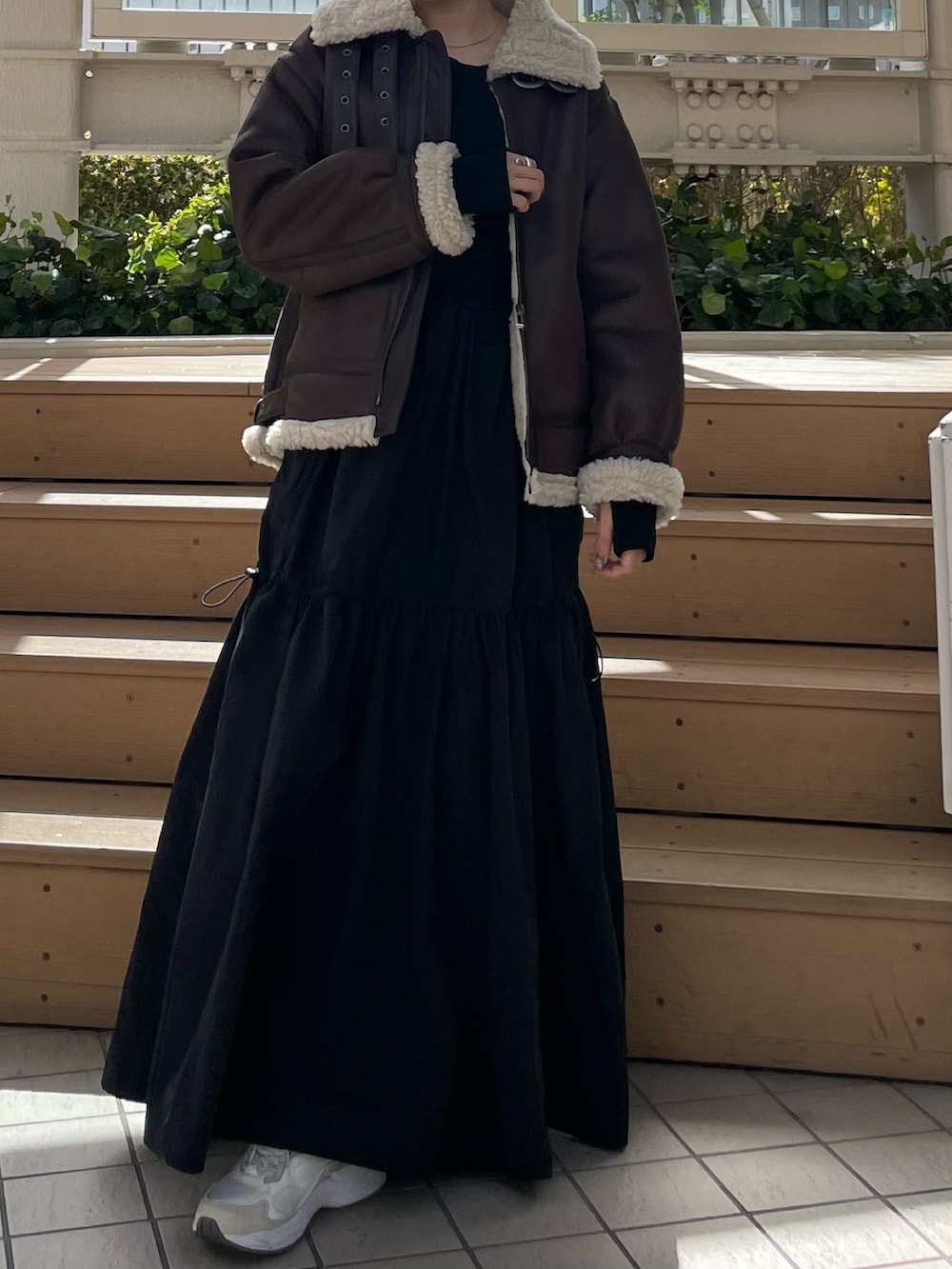 ブラック系のワンピース、ブラウン系のムートンコートを着用したレディースの秋コーディネートの4枚目の写真