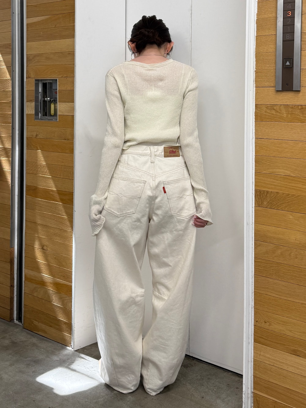 ホワイト系のデニムパンツ、ベージュ系のブーツ、ホワイト系のカーディガン/ボレロを着用したレディースの春コーディネートの7枚目の写真