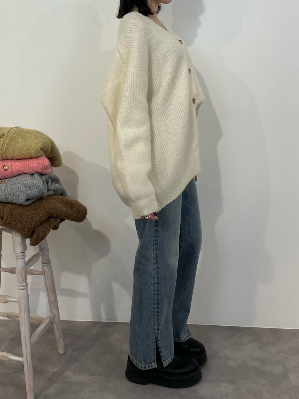 ブルー系のデニムパンツ、ブラック系のブーツ、ホワイト系のカーディガン/ボレロを着用したレディースの冬コーディネートの5枚目の写真