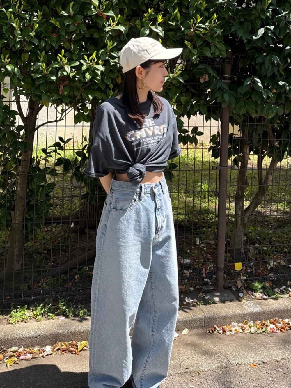 ブルー系のデニムパンツ、ブラック系のサンダル、グレー系のTシャツ/カットソーを着用したレディースの春コーディネートの3枚目の写真