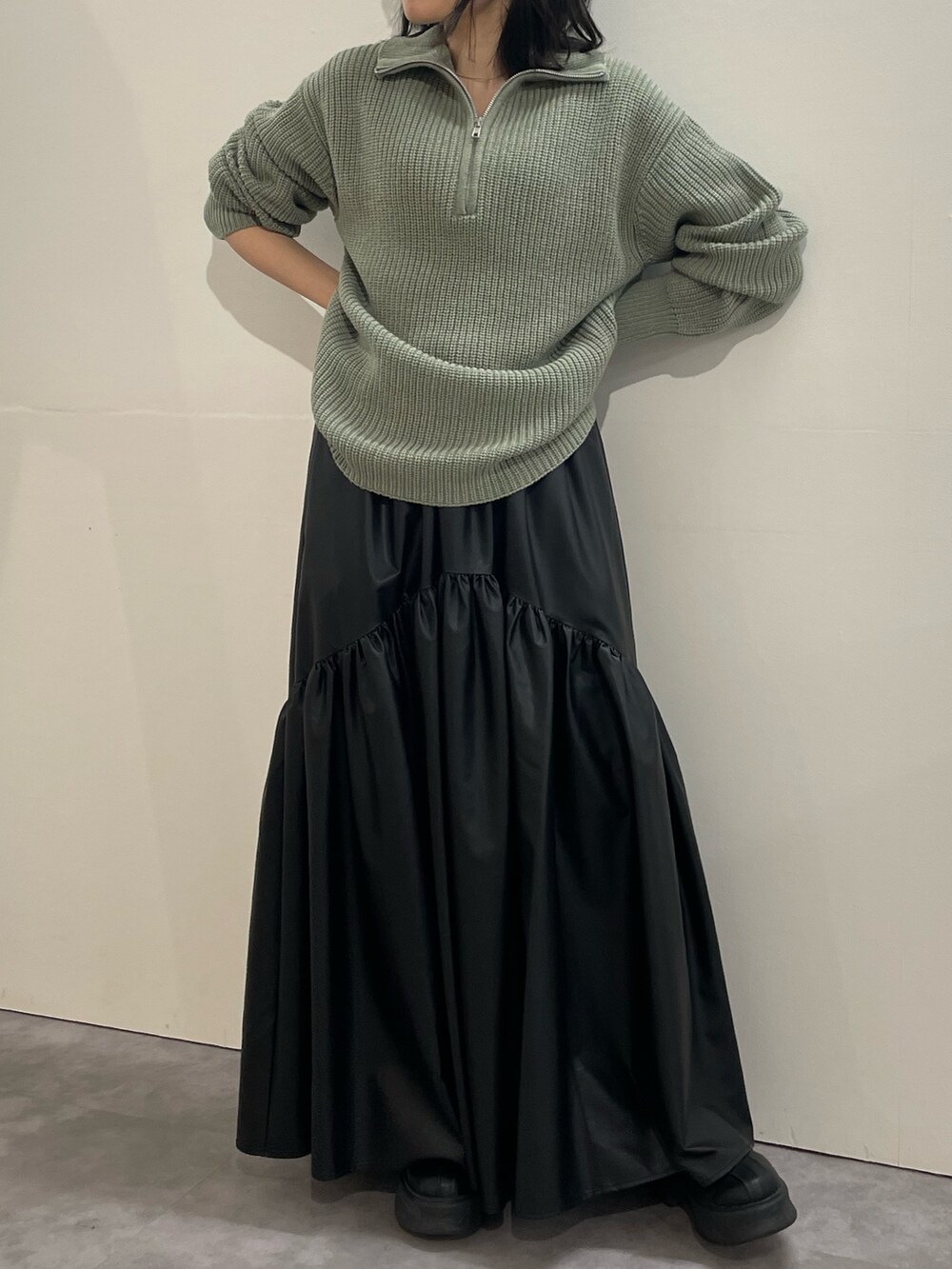 ブラック系のブーツ、ブラック系のスカート、グレー系のニット/セーターを着用したレディースの冬コーディネートの5枚目の写真