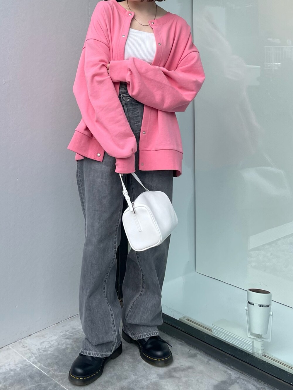 ピンク系のカーディガン/ボレロ、ホワイト系のハンドバッグ、ブラック系のデニムパンツを着用したレディースの冬コーディネートの6枚目の写真