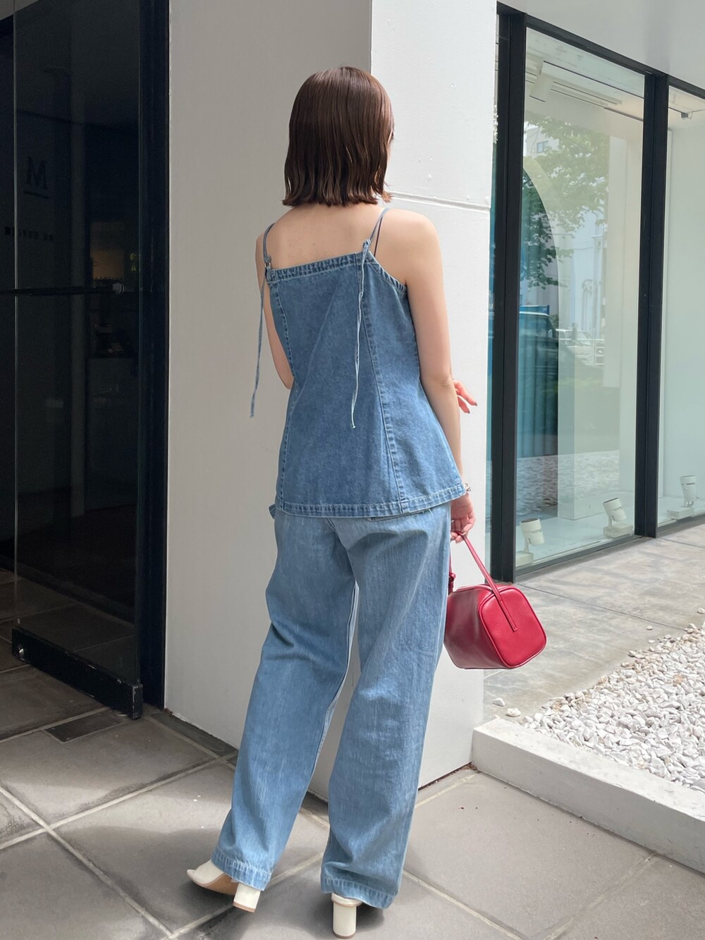 レッド系のハンドバッグ、ホワイト系のサンダル、ブルー系のキャミソールを着用したレディースの春コーディネートの3枚目の写真