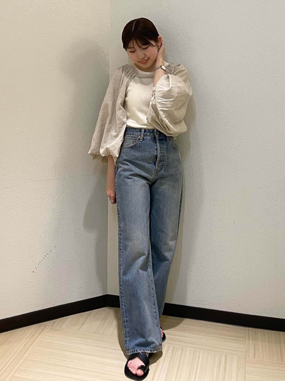 ベージュ系のシャツ/ブラウス、ブルー系のデニムパンツ、ブラック系のサンダルを着用したレディースの春コーディネートの6枚目の写真