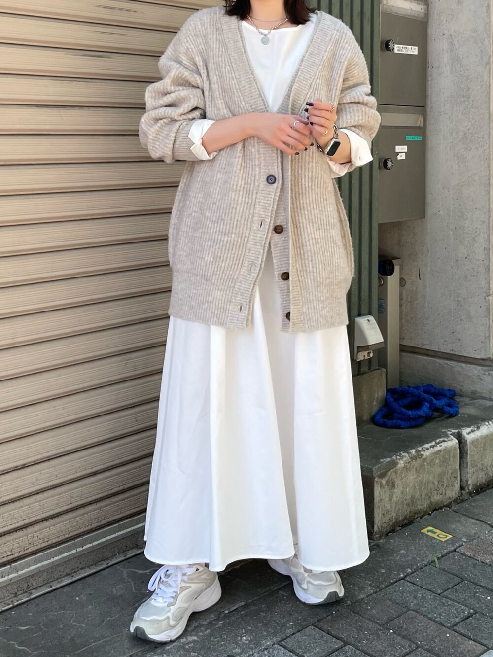 ホワイト系のカーディガン/ボレロ、ブラック系のワンピース、ブラック系のキャップを着用したレディースの秋コーディネートの5枚目の写真