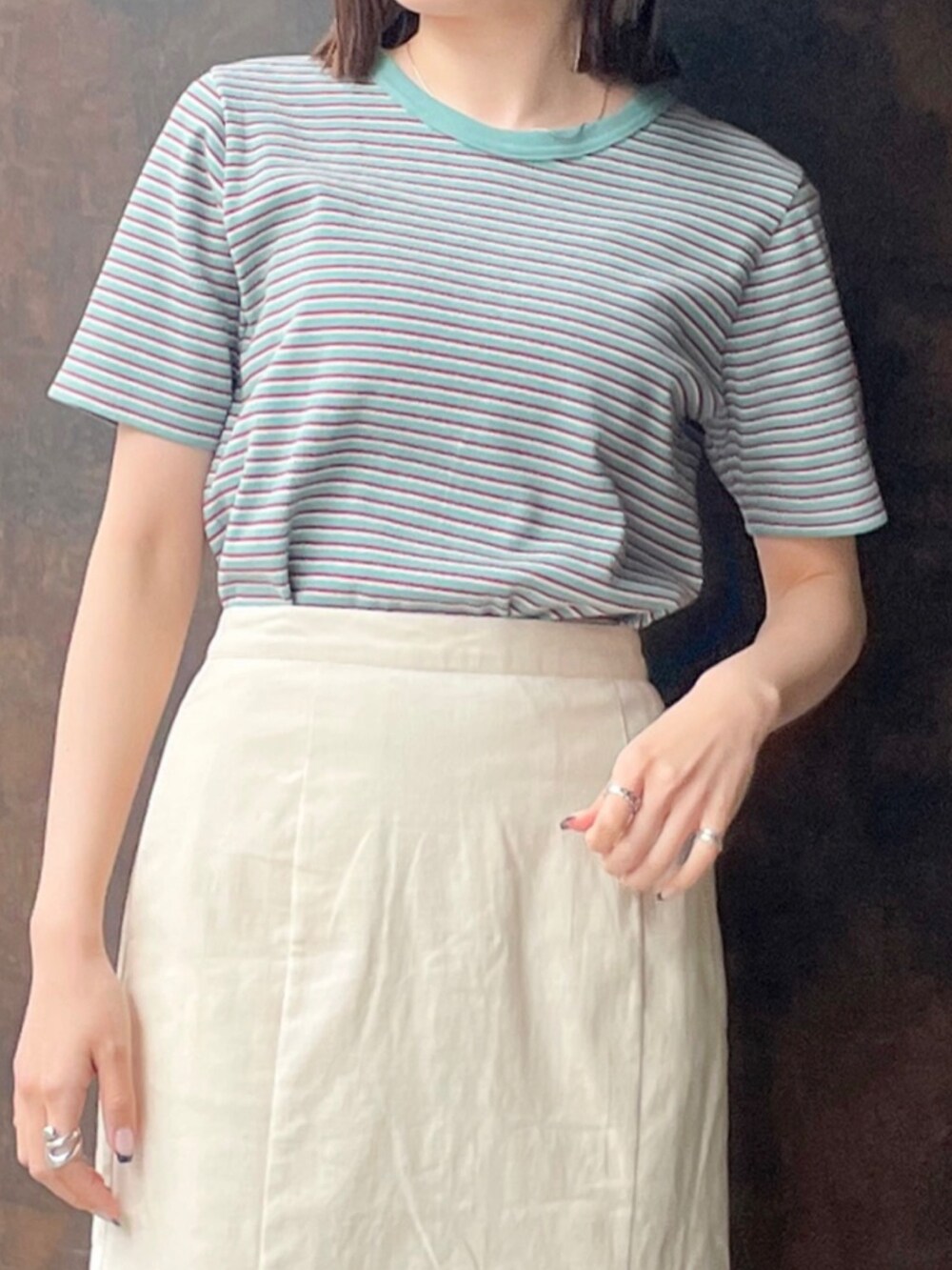 グリーン系のTシャツ/カットソー、ホワイト系のサンダル、ホワイト系のスカートを着用したレディースの春コーディネートの5枚目の写真