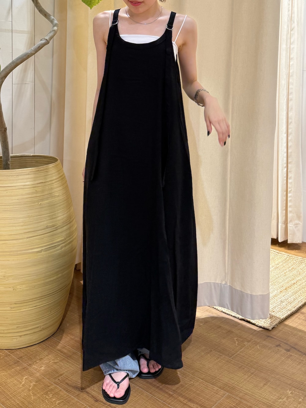 ブラック系のワンピース、ブルー系のデニムパンツ、ブラック系のサンダルを着用したレディースの夏コーディネートの5枚目の写真