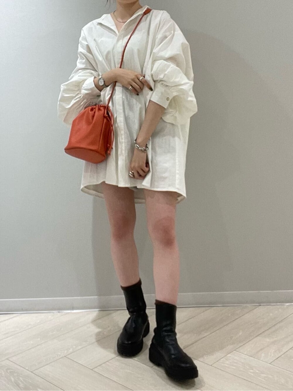 グレー系のスウェットパンツ、オレンジ系のハンドバッグ、ホワイト系のシャツ/ブラウスを着用したレディースの秋コーディネートの2枚目の写真