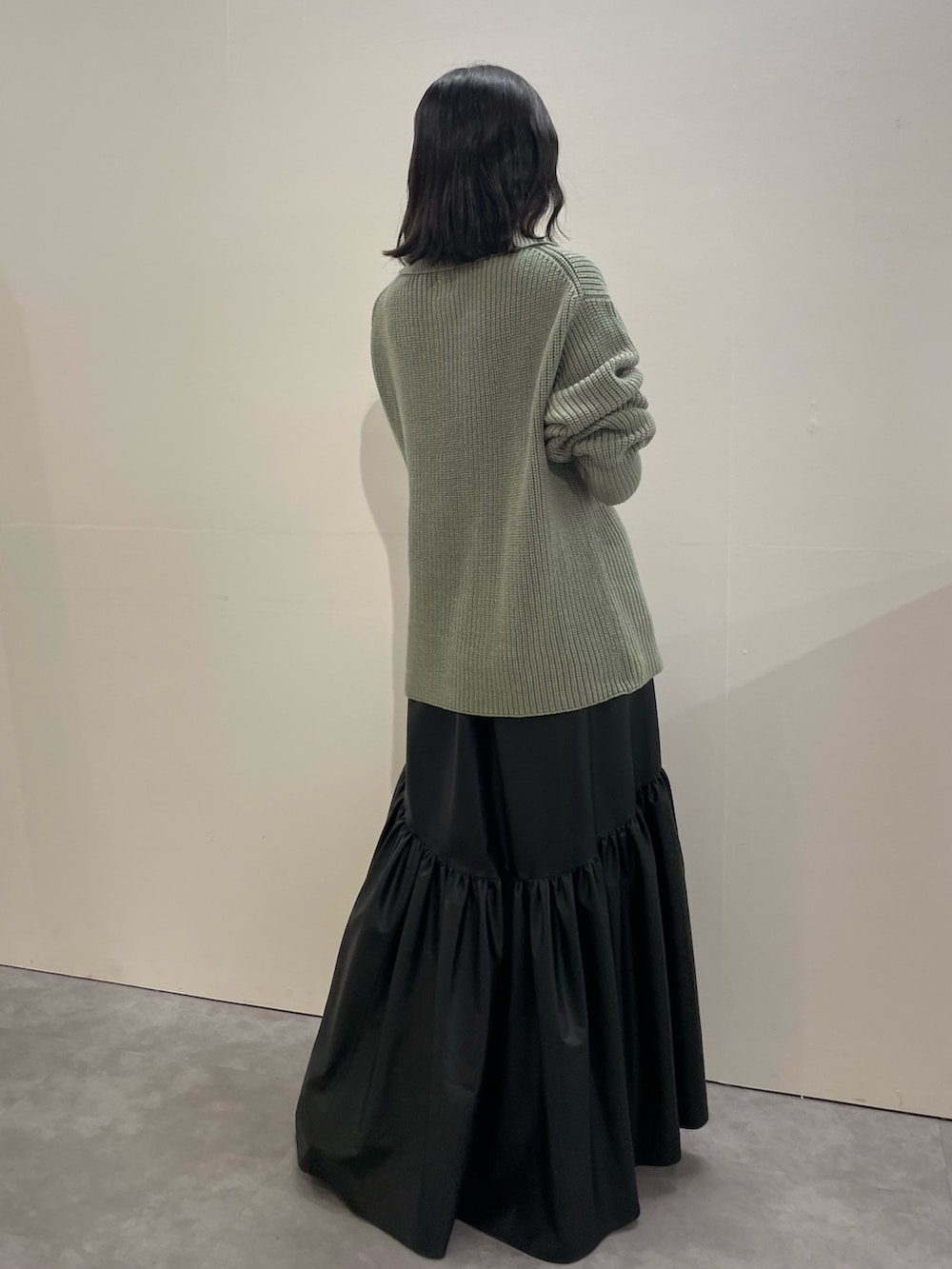 ブラック系のブーツ、ブラック系のスカート、グレー系のニット/セーターを着用したレディースの冬コーディネートの3枚目の写真