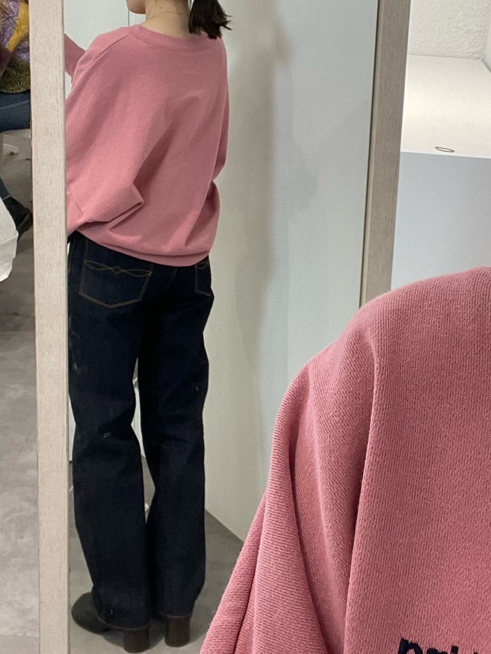 ブラック系のブーツ、ピンク系のスウェット、ブルー系のデニムパンツを着用したレディースの冬コーディネートの5枚目の写真