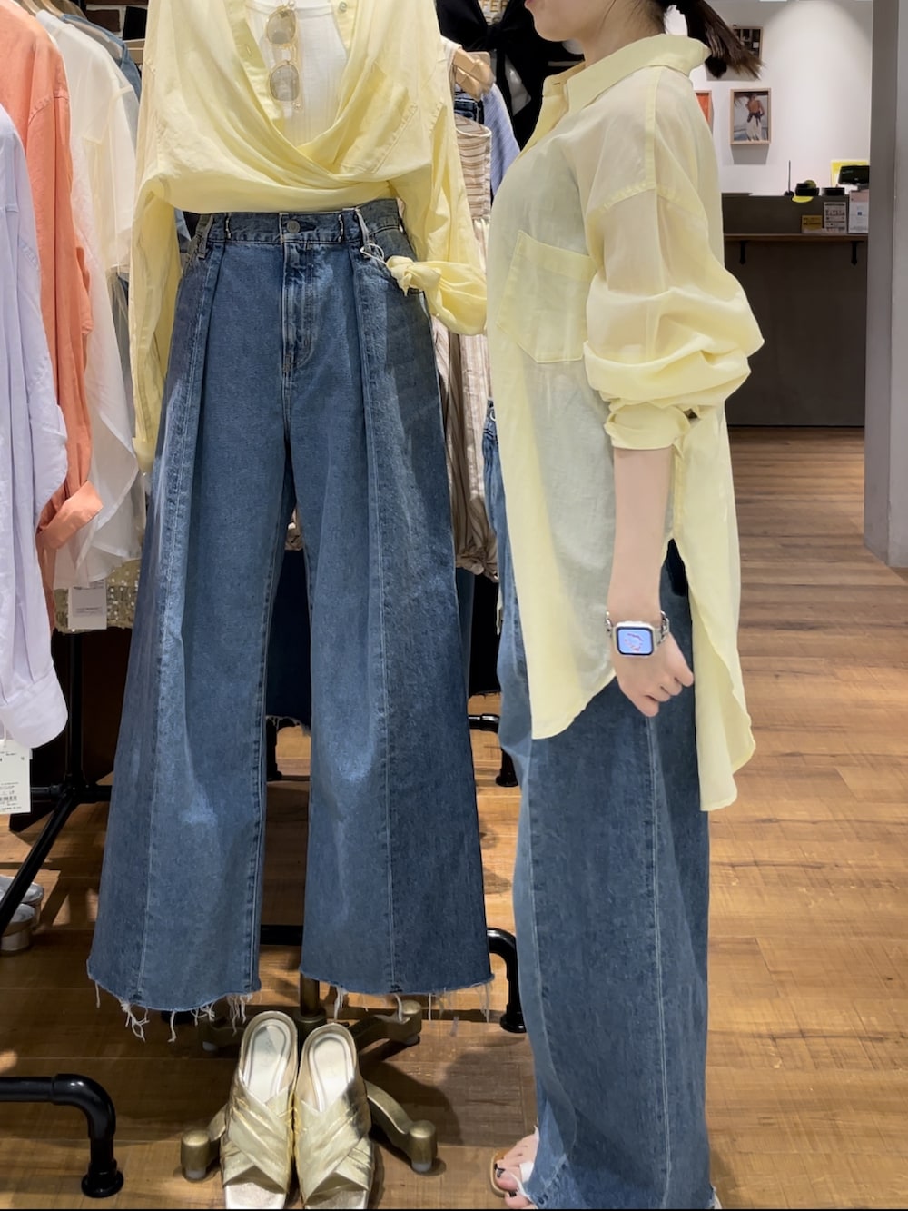 ブルー系のデニムパンツ、グレー系のキャミソール、ホワイト系のサンダルを着用したレディースの春コーディネートの3枚目の写真