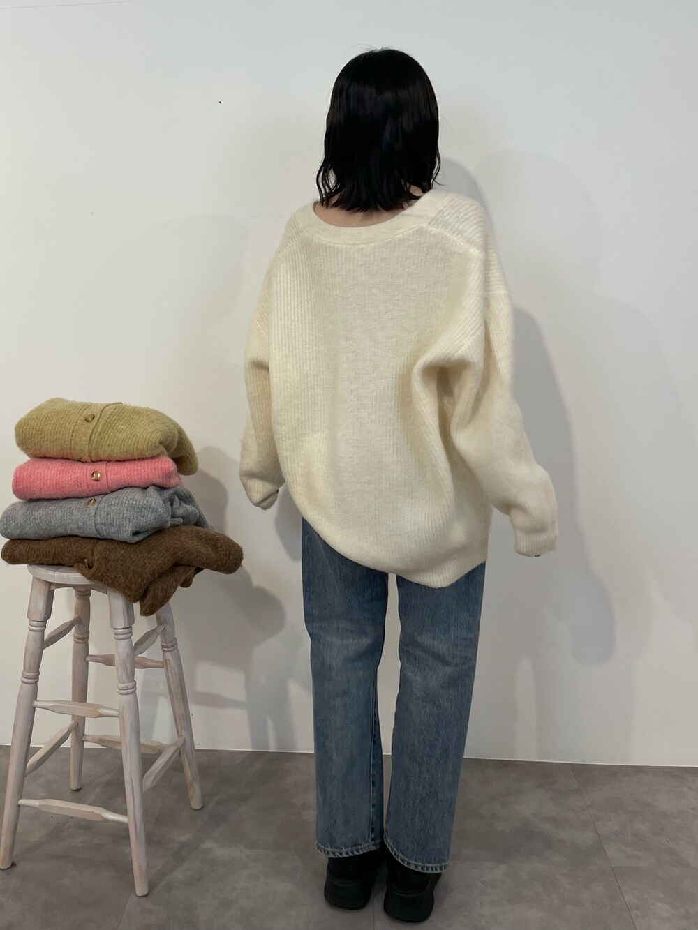 ブルー系のデニムパンツ、ブラック系のブーツ、ホワイト系のカーディガン/ボレロを着用したレディースの冬コーディネートの4枚目の写真