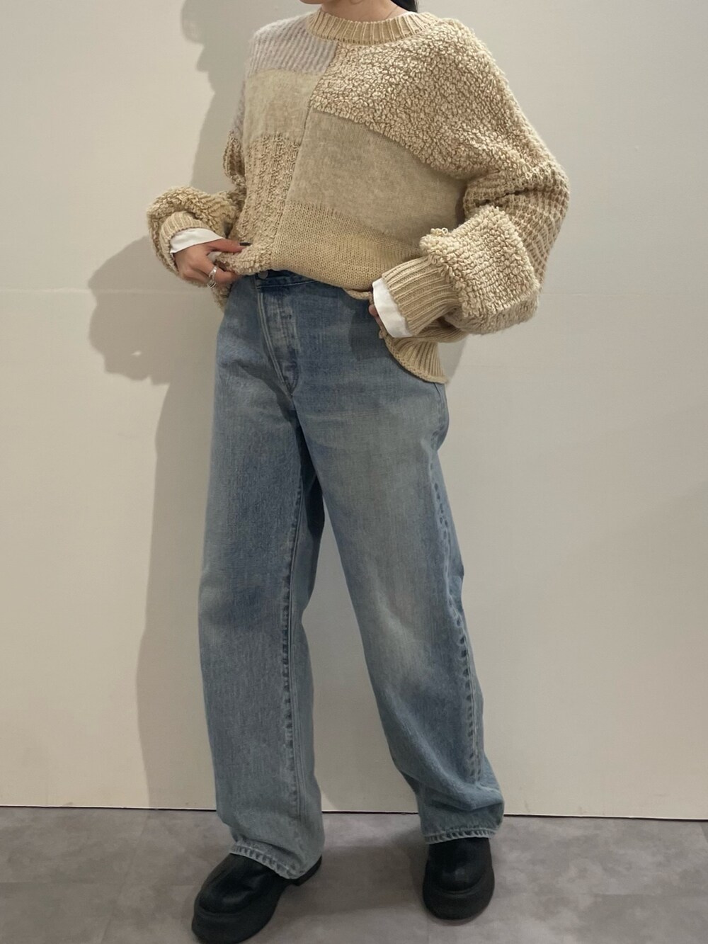 ホワイト系のTシャツ/カットソー、ブルー系のデニムパンツ、ブラック系のブーツを着用したレディースの冬コーディネートの3枚目の写真