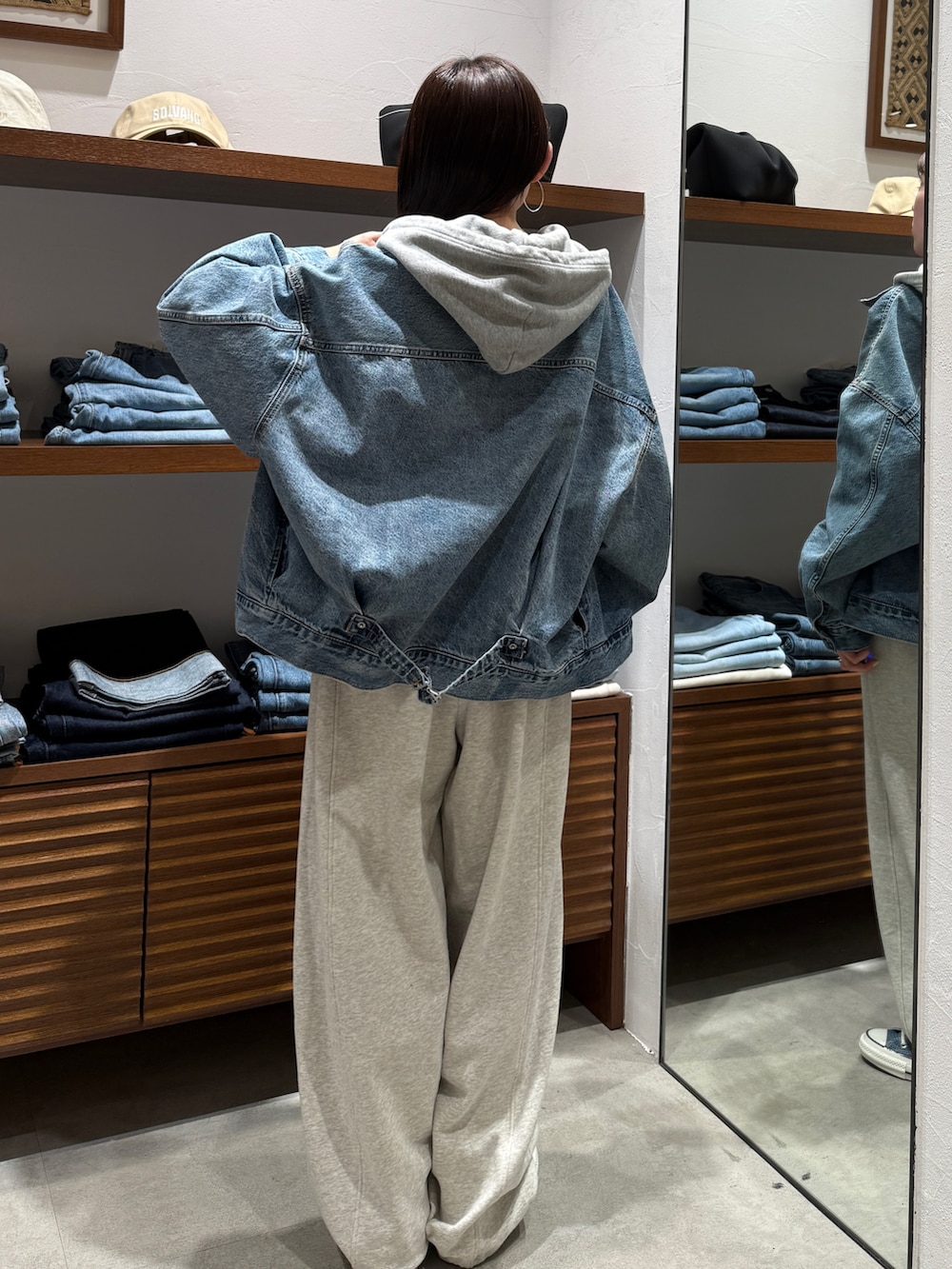 ホワイト系のスウェットパンツ、ブルー系のスニーカー、ブルー系のデニムジャケットを着用したレディースの春コーディネートの4枚目の写真