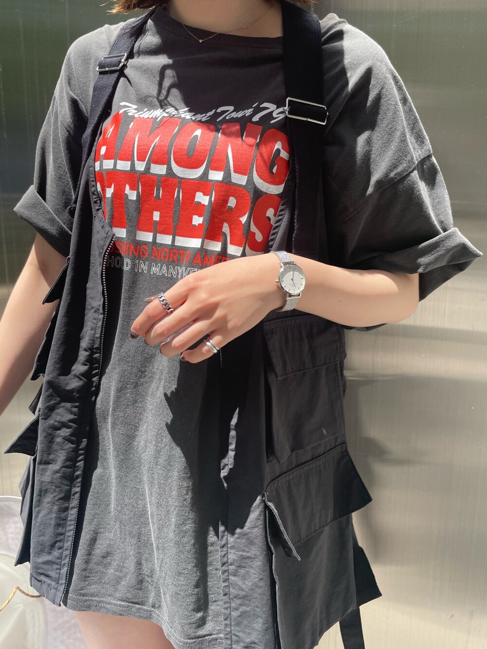 グレー系のTシャツ/カットソー、ブラック系のベスト、ホワイト系のハットを着用したレディースの春コーディネートの4枚目の写真