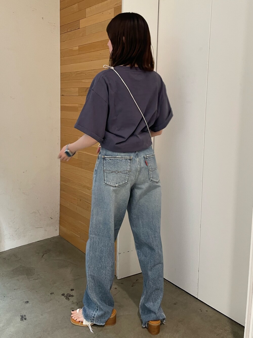 ホワイト系のサンダル、ブルー系のデニムパンツ、シルバー系のショルダーバッグを着用したレディースの春コーディネートの6枚目の写真
