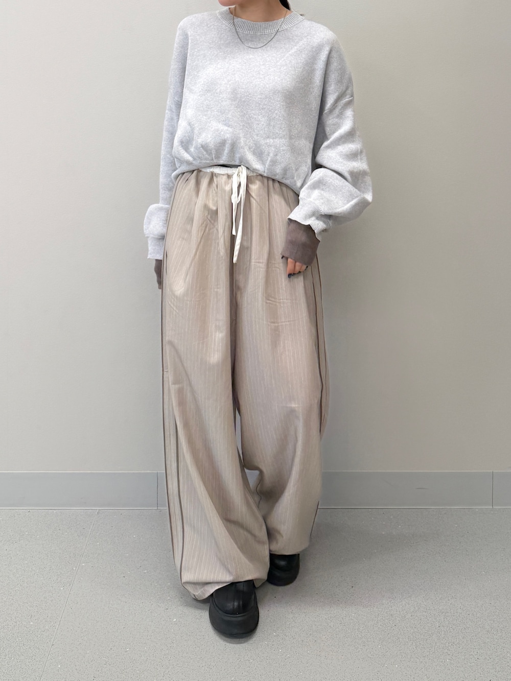 ベージュ系のその他パンツ、グレー系のニット/セーター、ブラック系のブーツを着用したレディースの冬コーディネートの5枚目の写真