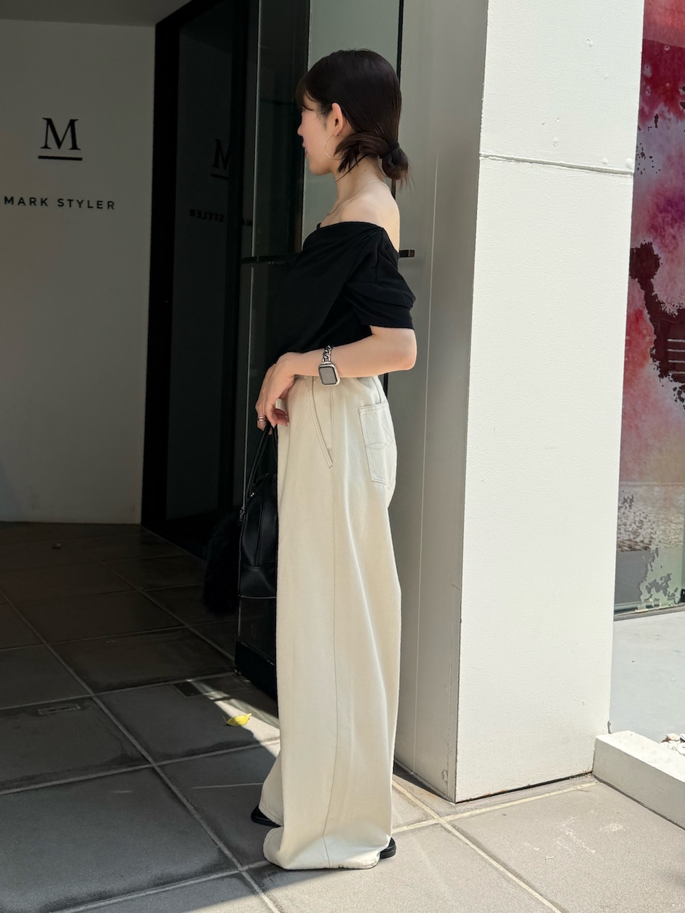 ブラック系のTシャツ/カットソー、ブラック系のサンダル、ブラック系のハンドバッグを着用したレディースの夏コーディネートの4枚目の写真