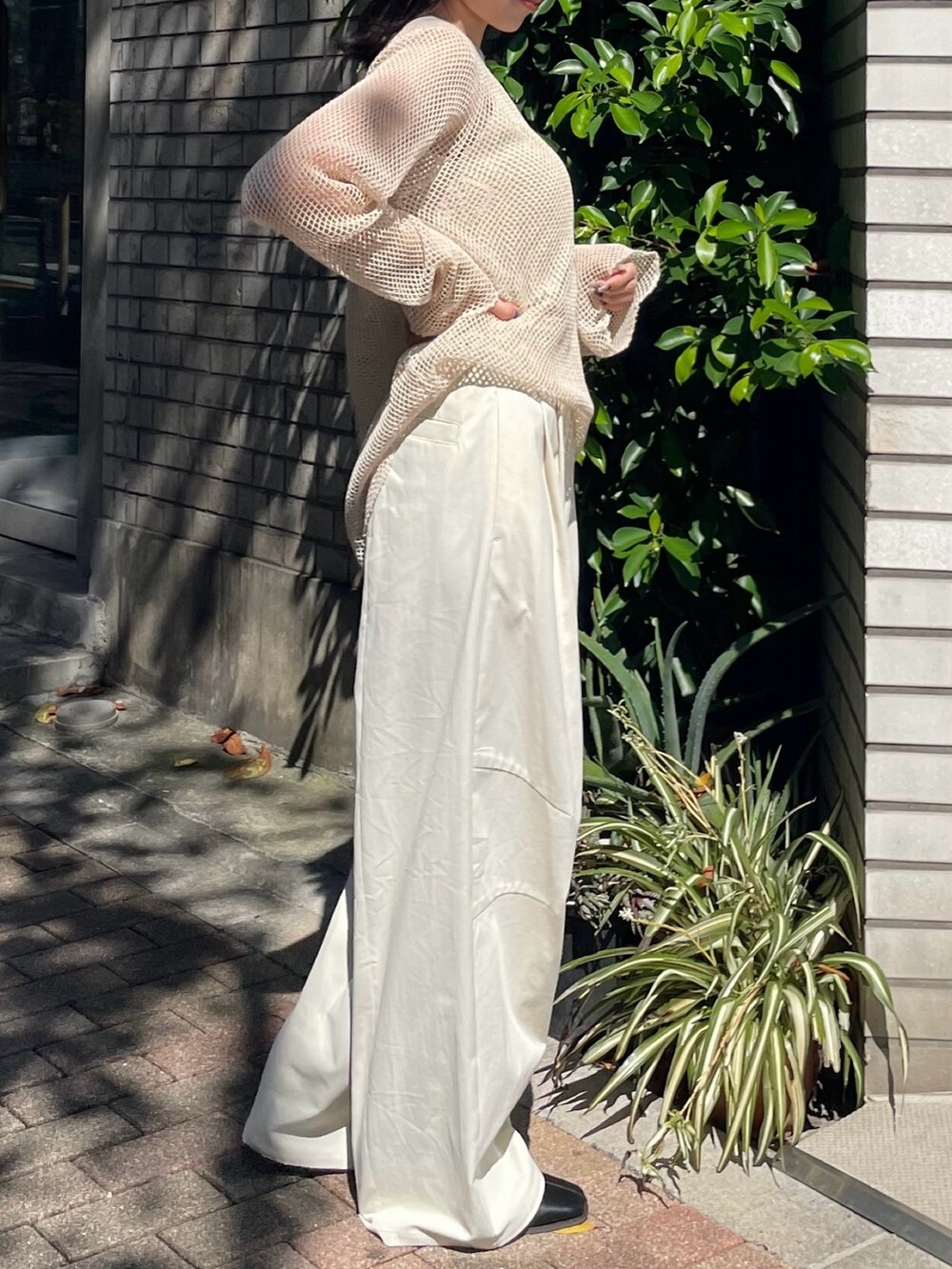 ブラック系のブーツ、ホワイト系のチノパンツ、ホワイト系のTシャツ/カットソーを着用したレディースの冬コーディネートの2枚目の写真