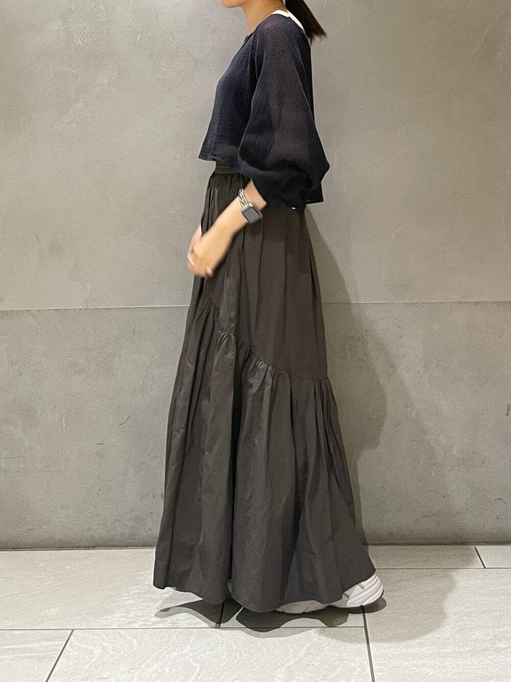 グレー系のスカート、グレー系のTシャツ/カットソーを着用したレディースの夏コーディネートの4枚目の写真