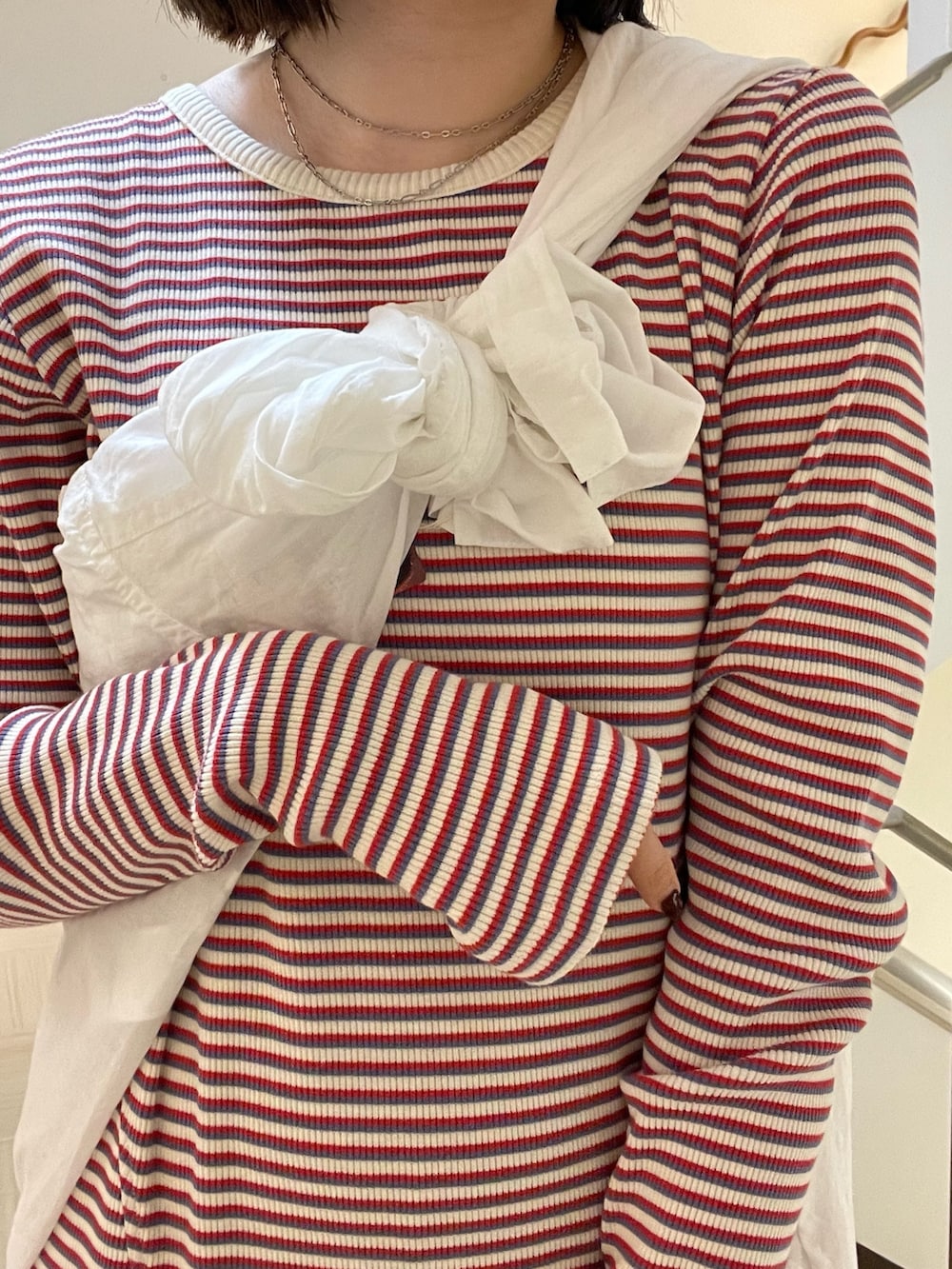 レッド系のワンピース、ホワイト系のシャツ/ブラウス、シルバー系のネックレスを着用したレディースの春コーディネートの7枚目の写真