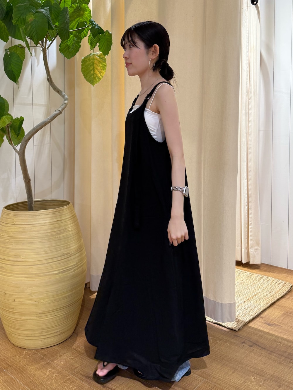 ブラック系のワンピース、ブルー系のデニムパンツ、ブラック系のサンダルを着用したレディースの夏コーディネートの6枚目の写真