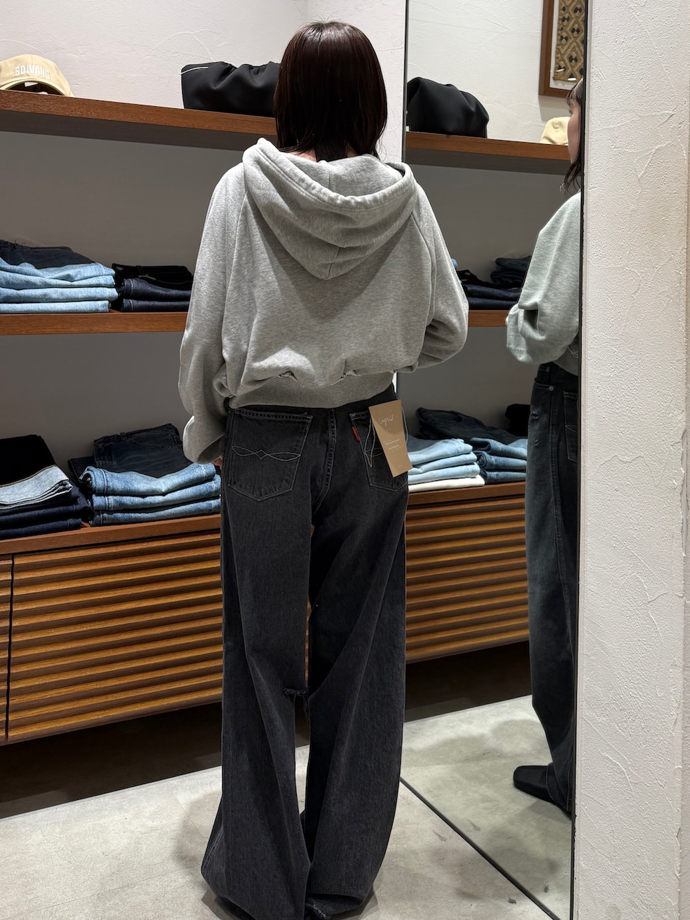 ブラック系のサンダル、グレー系のパーカー、ブラック系のデニムパンツを着用したレディースの春コーディネートの4枚目の写真