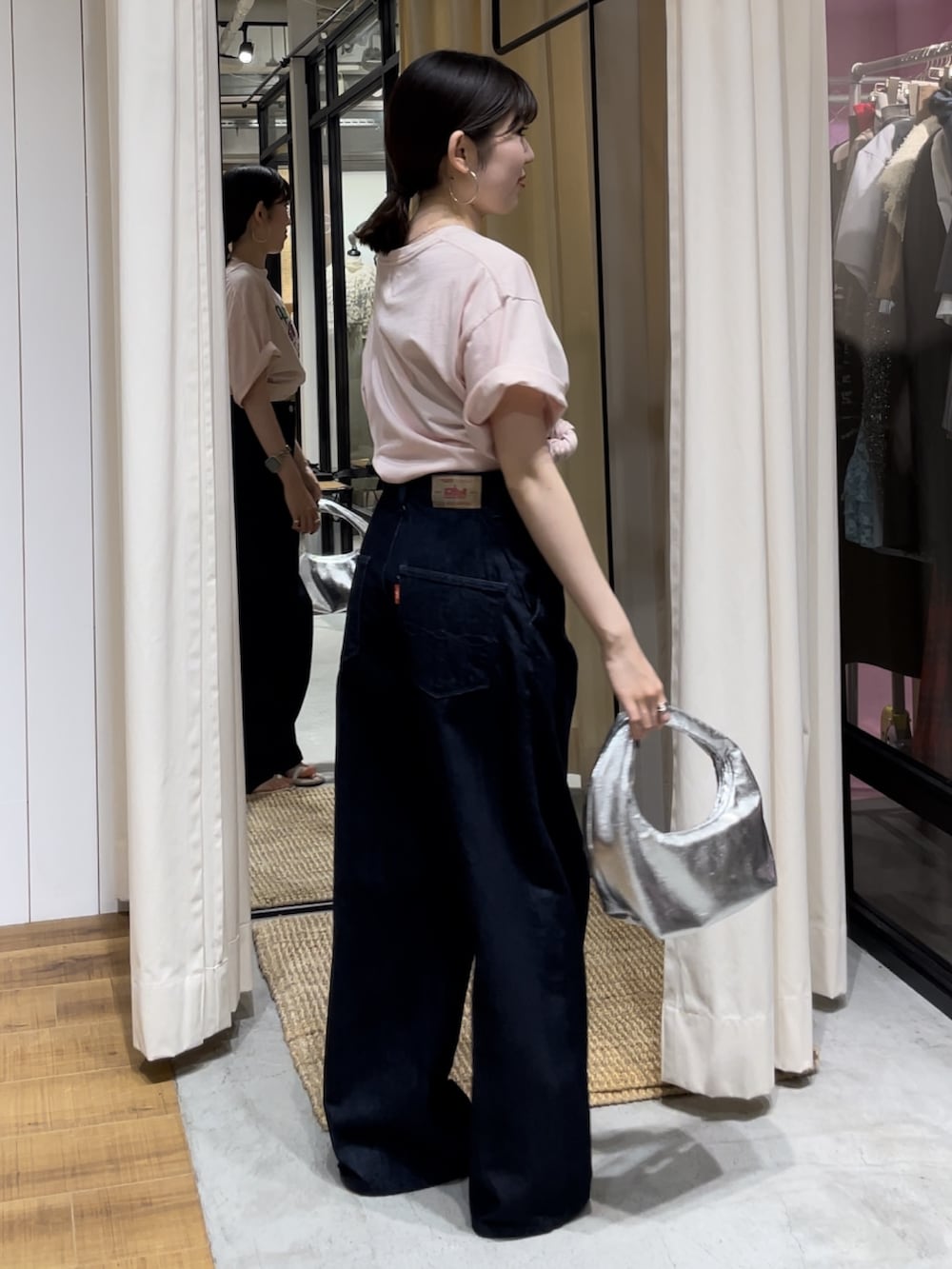 シルバー系のハンドバッグ、ホワイト系のサンダル、ピンク系のTシャツ/カットソーを着用したレディースの夏コーディネートの2枚目の写真