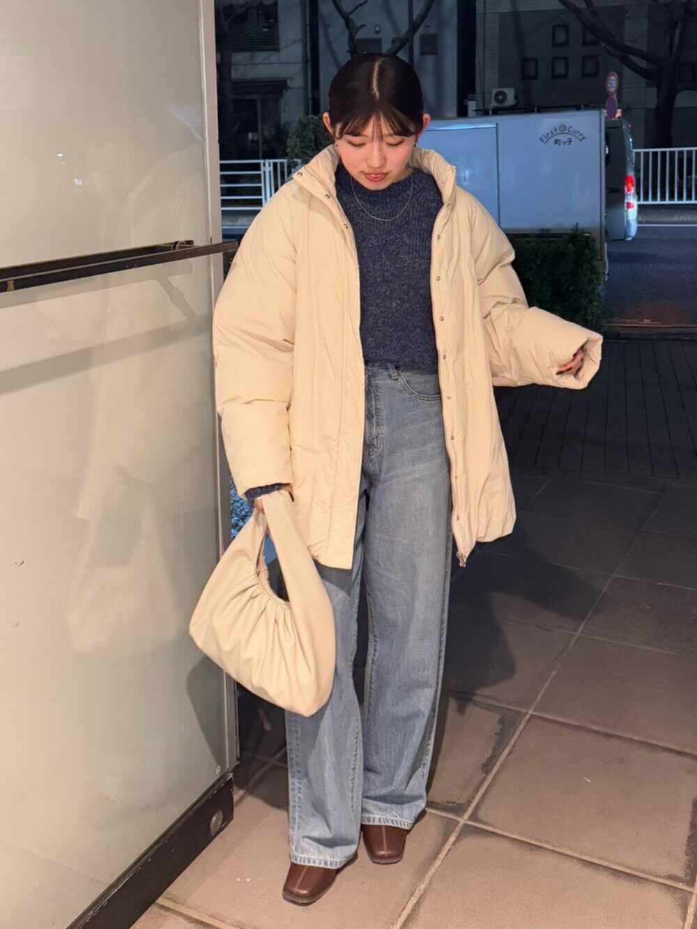 ブラウン系のブーツ、ブルー系のデニムパンツ、ホワイト系のブルゾンを着用したレディースの冬コーディネートの2枚目の写真