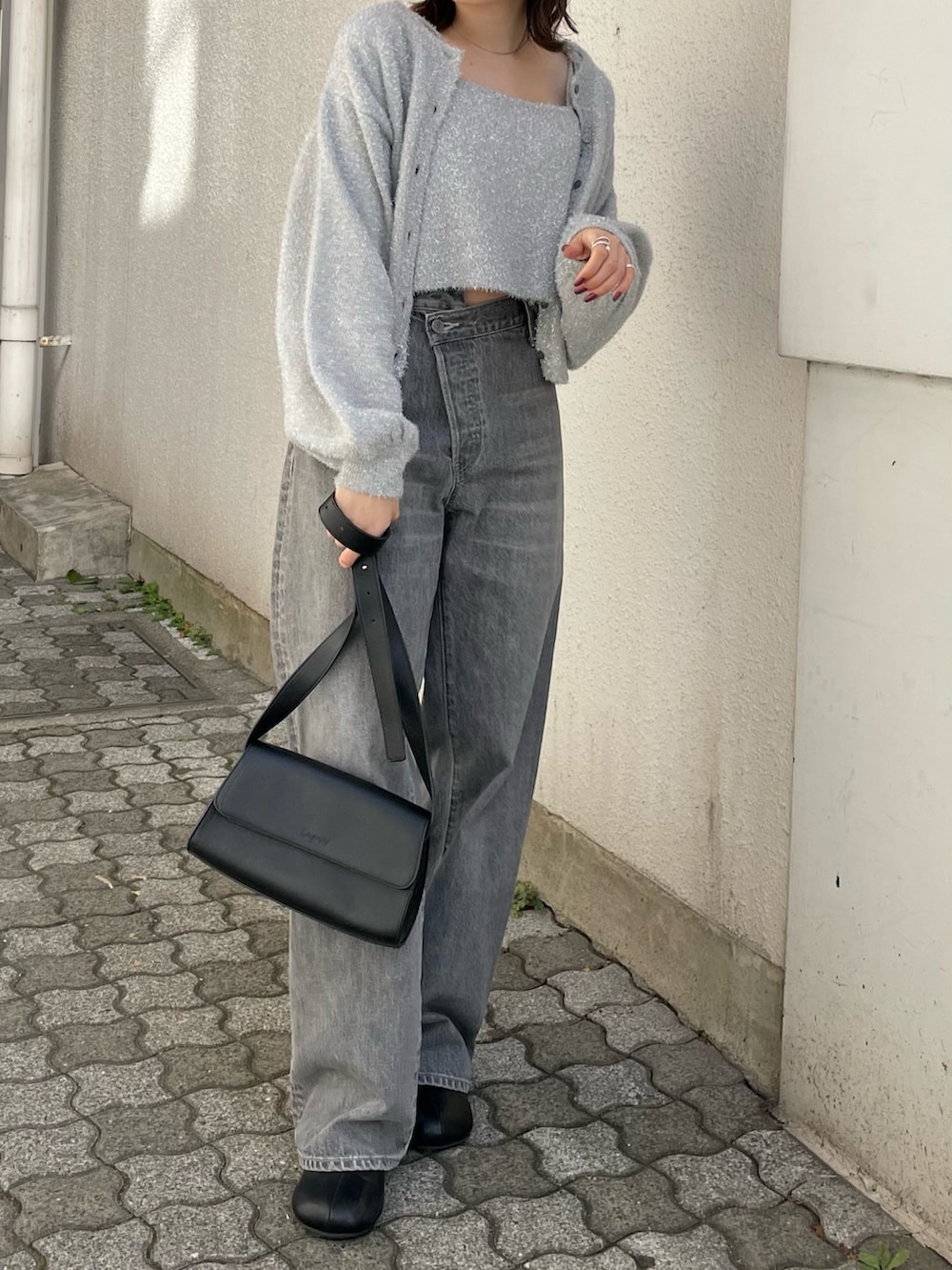 ブラック系のショルダーバッグ、ブラック系のブーツ、ブラック系のデニムパンツを着用したレディースの冬コーディネートの4枚目の写真