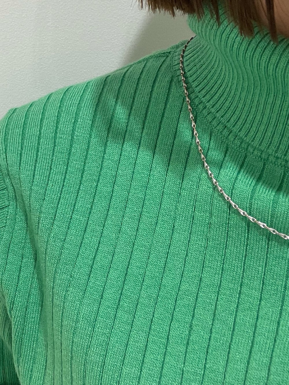 ブラック系のブーツ、ホワイト系のカーゴパンツ、グリーン系のニット/セーターを着用したレディースの冬コーディネートの6枚目の写真