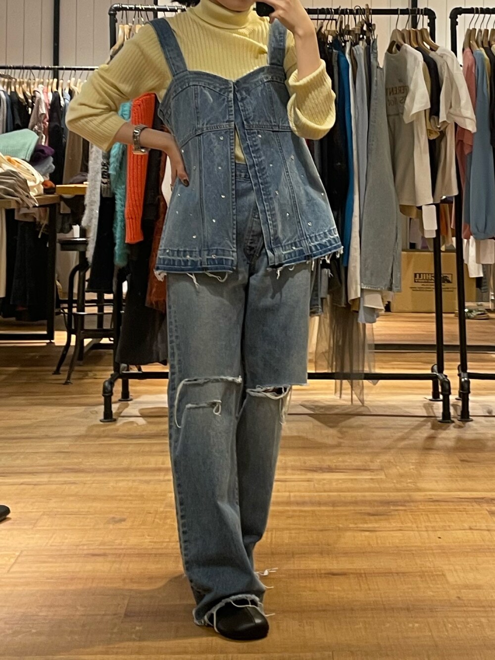 ブラック系のブーツ、ブルー系のタンクトップ、イエロー系のニット/セーターを着用したレディースの秋コーディネートの3枚目の写真