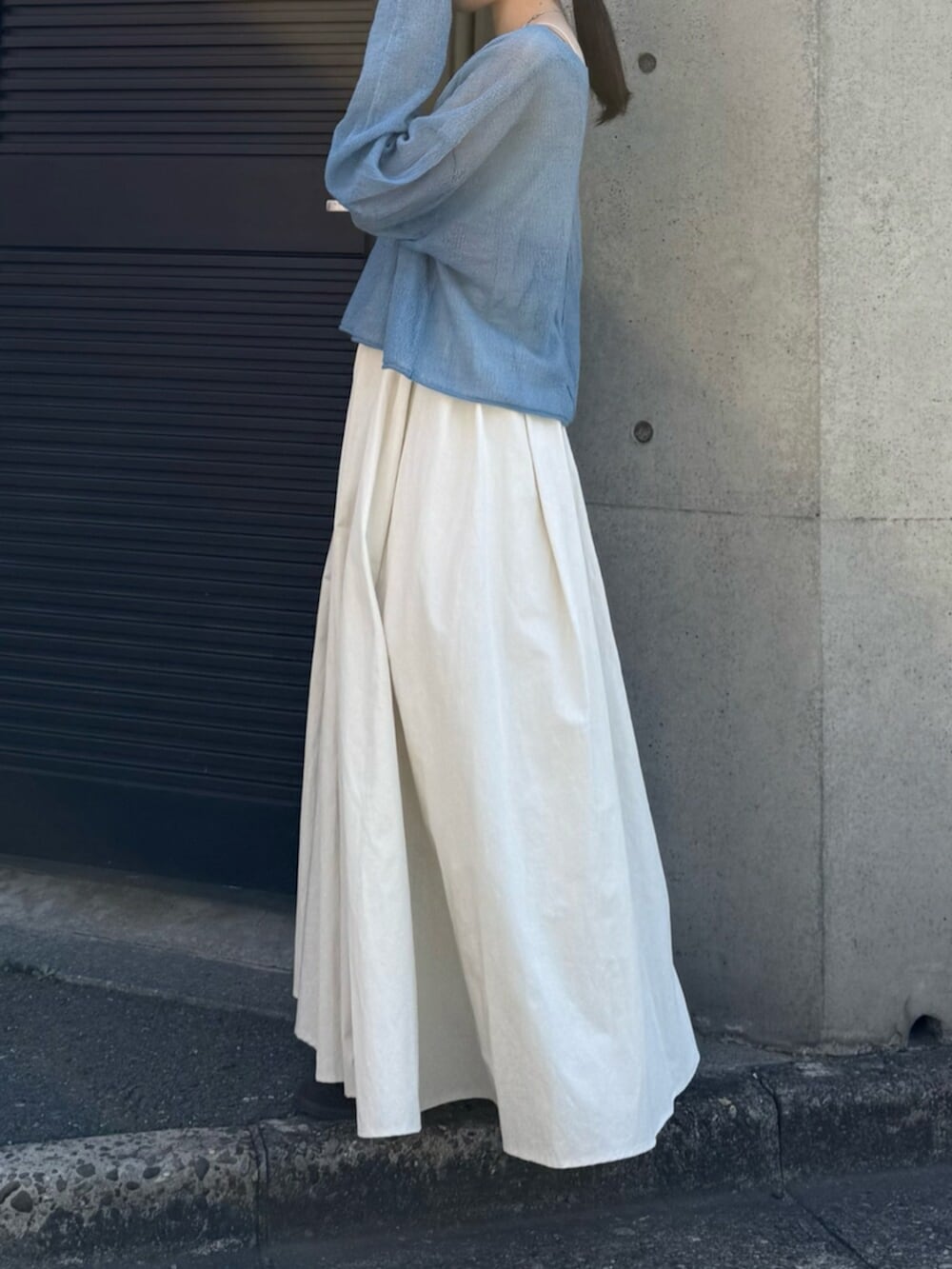 ホワイト系のスカート、ブラウン系のブーツ、ブルー系のニット/セーターを着用したレディースの秋コーディネートの3枚目の写真