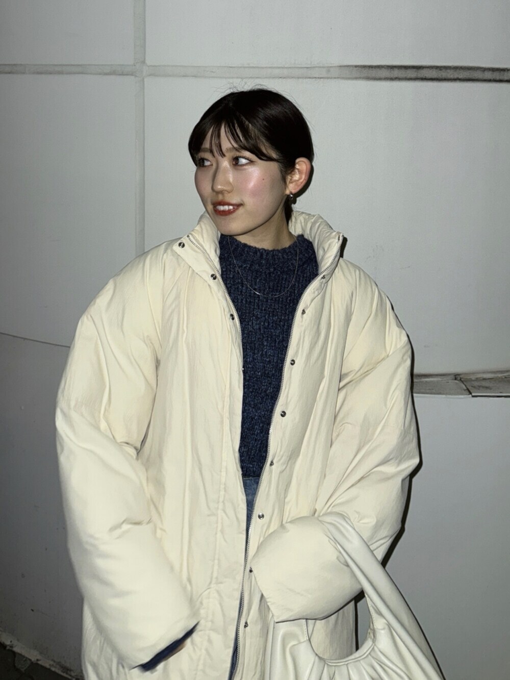 ブラウン系のブーツ、ブルー系のデニムパンツ、ホワイト系のブルゾンを着用したレディースの冬コーディネートの6枚目の写真
