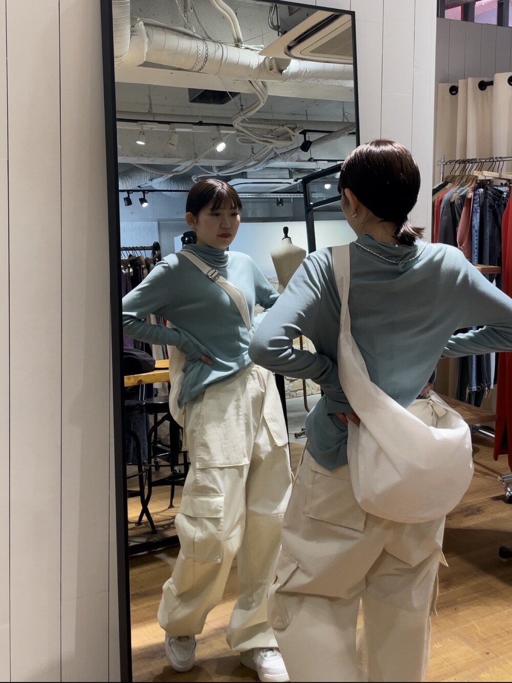 ホワイト系のカーゴパンツ、ホワイト系のショルダーバッグ、ブルー系のTシャツ/カットソーを着用したレディースの夏コーディネートの4枚目の写真