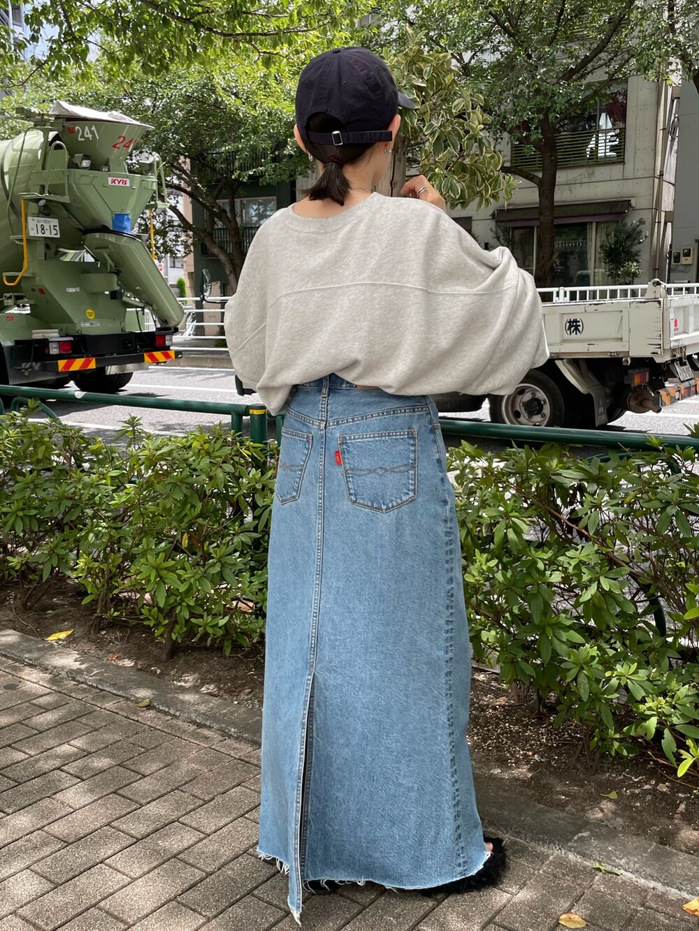 ブルー系のデニムスカート、グレー系のスウェット、ブラック系のサンダルを着用したレディースの夏コーディネートの5枚目の写真