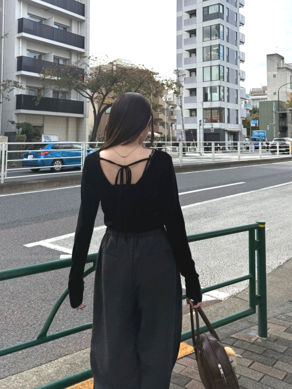 ブラウン系のハンドバッグ、グレー系のその他パンツ、ブラック系のTシャツ/カットソーを着用したレディースの秋コーディネートの6枚目の写真