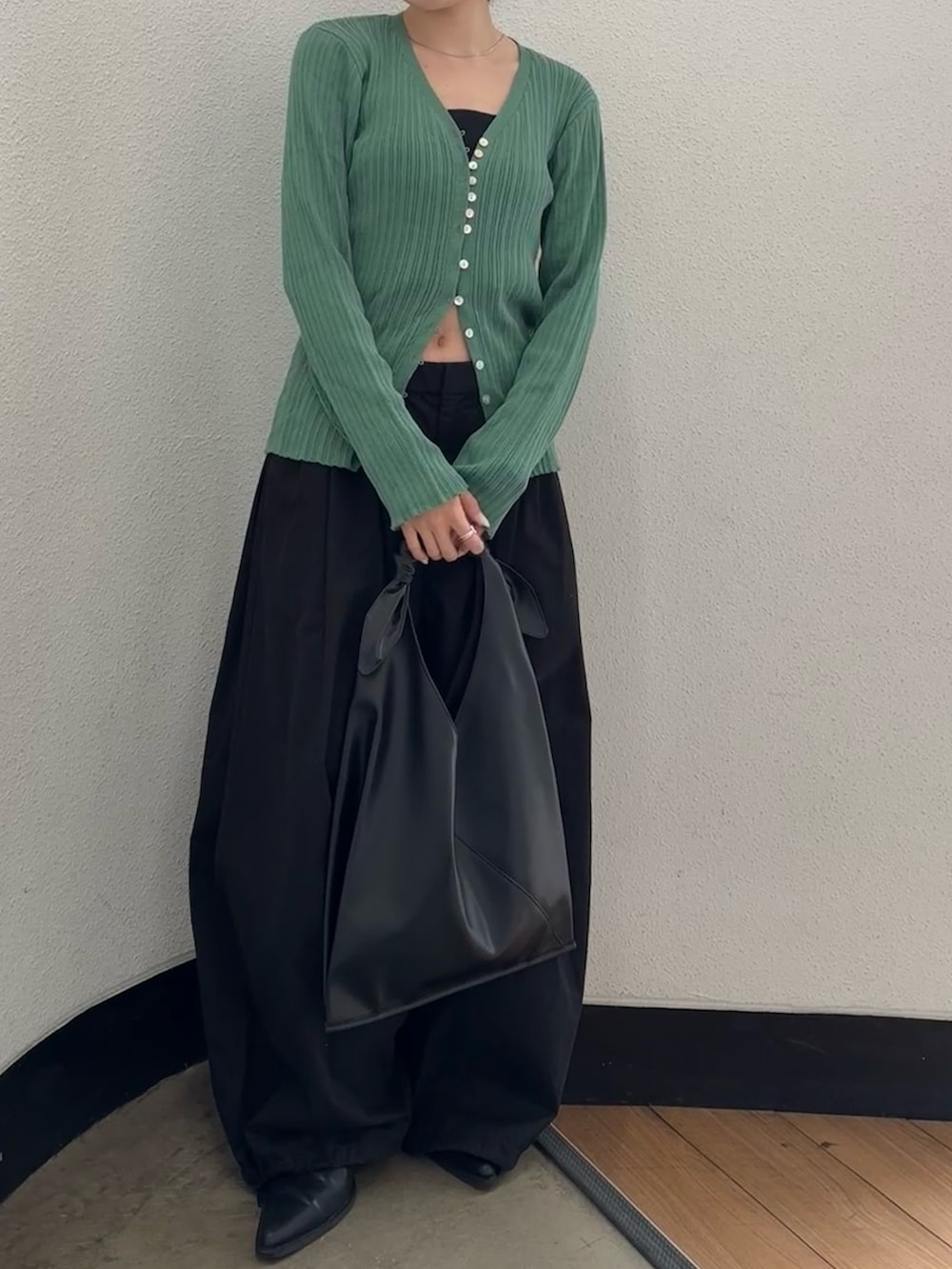 ブラック系のその他パンツ、ブラック系のハンドバッグ、ブラック系のブーツを着用したレディースの春コーディネートの6枚目の写真