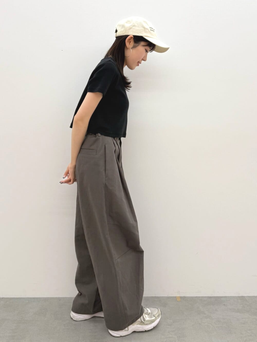 ブラック系のTシャツ/カットソー、グレー系のチノパンツ、ホワイト系のキャップを着用したレディースの春コーディネートの2枚目の写真