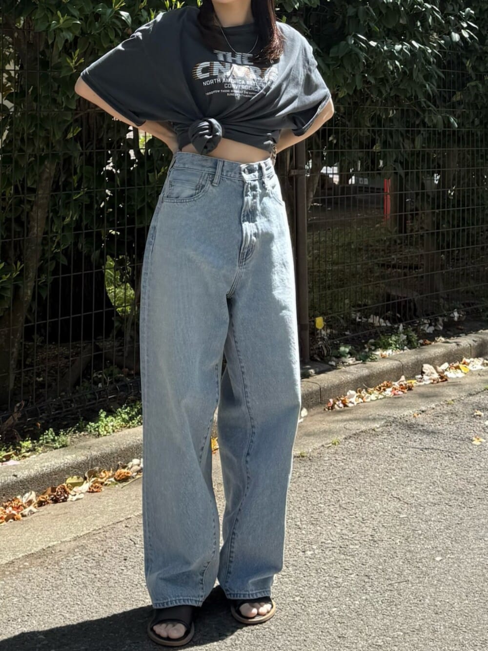 ブルー系のデニムパンツ、ブラック系のサンダル、グレー系のTシャツ/カットソーを着用したレディースの春コーディネートの8枚目の写真