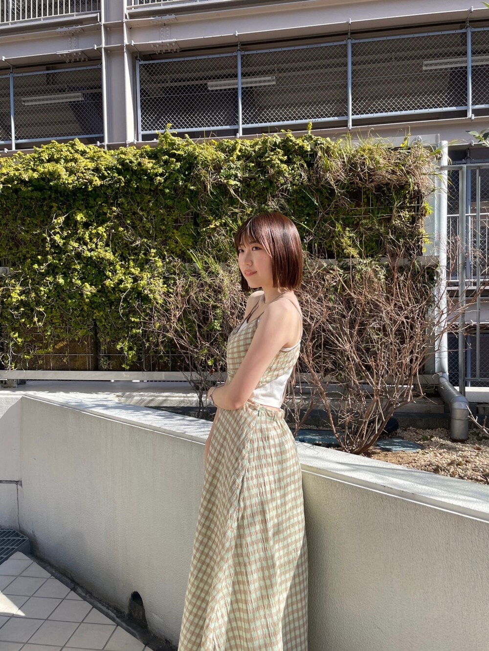 ホワイト系のハンドバッグ、グリーン系のワンピース、ブルー系のデニムジャケットを着用したレディースの冬コーディネートの4枚目の写真