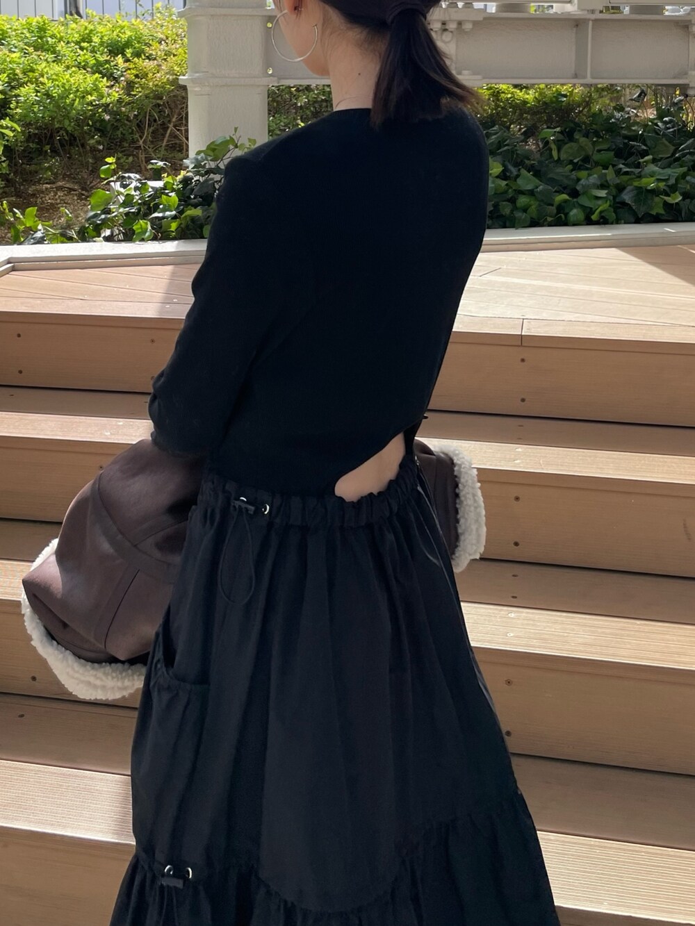 ブラック系のワンピース、ブラウン系のムートンコートを着用したレディースの秋コーディネートの7枚目の写真