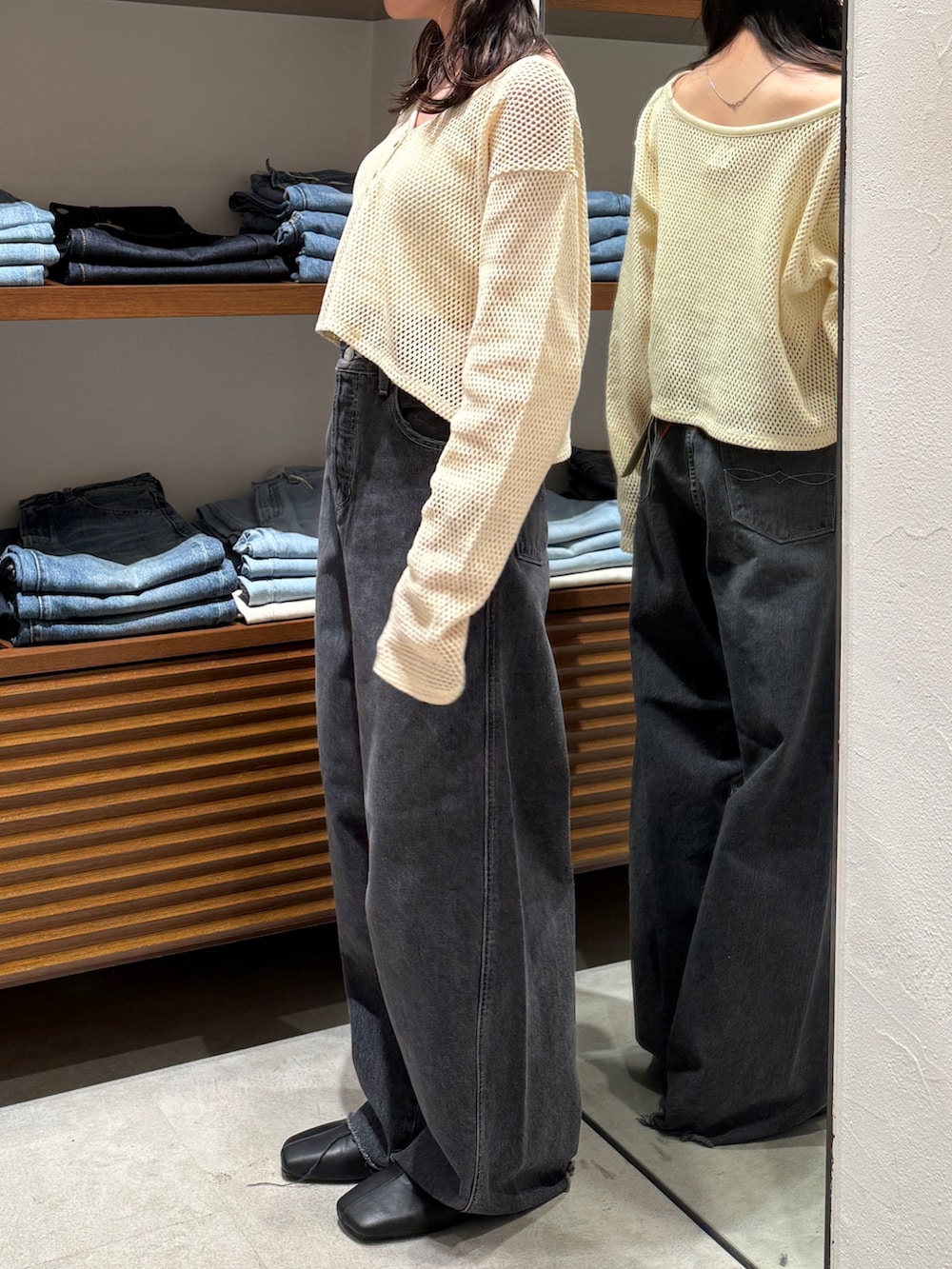 ブラック系のデニムパンツ、ブラック系のサンダル、ホワイト系のカーディガン/ボレロを着用したレディースの春コーディネートの2枚目の写真