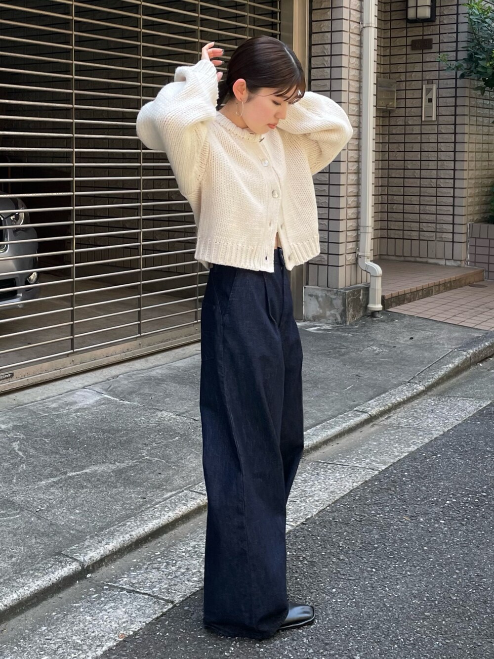 ブラック系のローファー、ブルー系のデニムパンツ、ホワイト系のカーディガン/ボレロを着用したレディースの秋コーディネートの5枚目の写真
