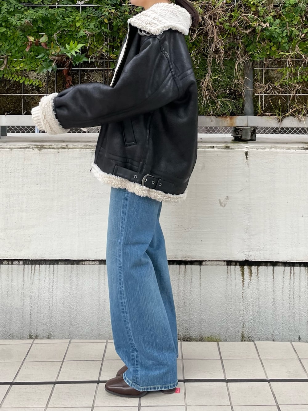 ブルー系のデニムパンツ、ブラウン系のブーツ、ホワイト系のニット/セーターを着用したレディースの秋コーディネートの3枚目の写真