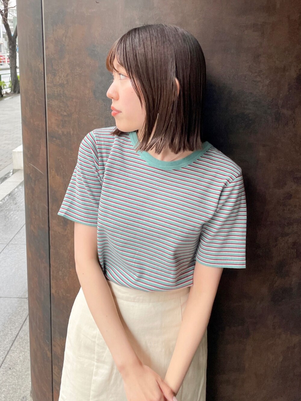 グリーン系のTシャツ/カットソー、ホワイト系のサンダル、ホワイト系のスカートを着用したレディースの春コーディネートの4枚目の写真