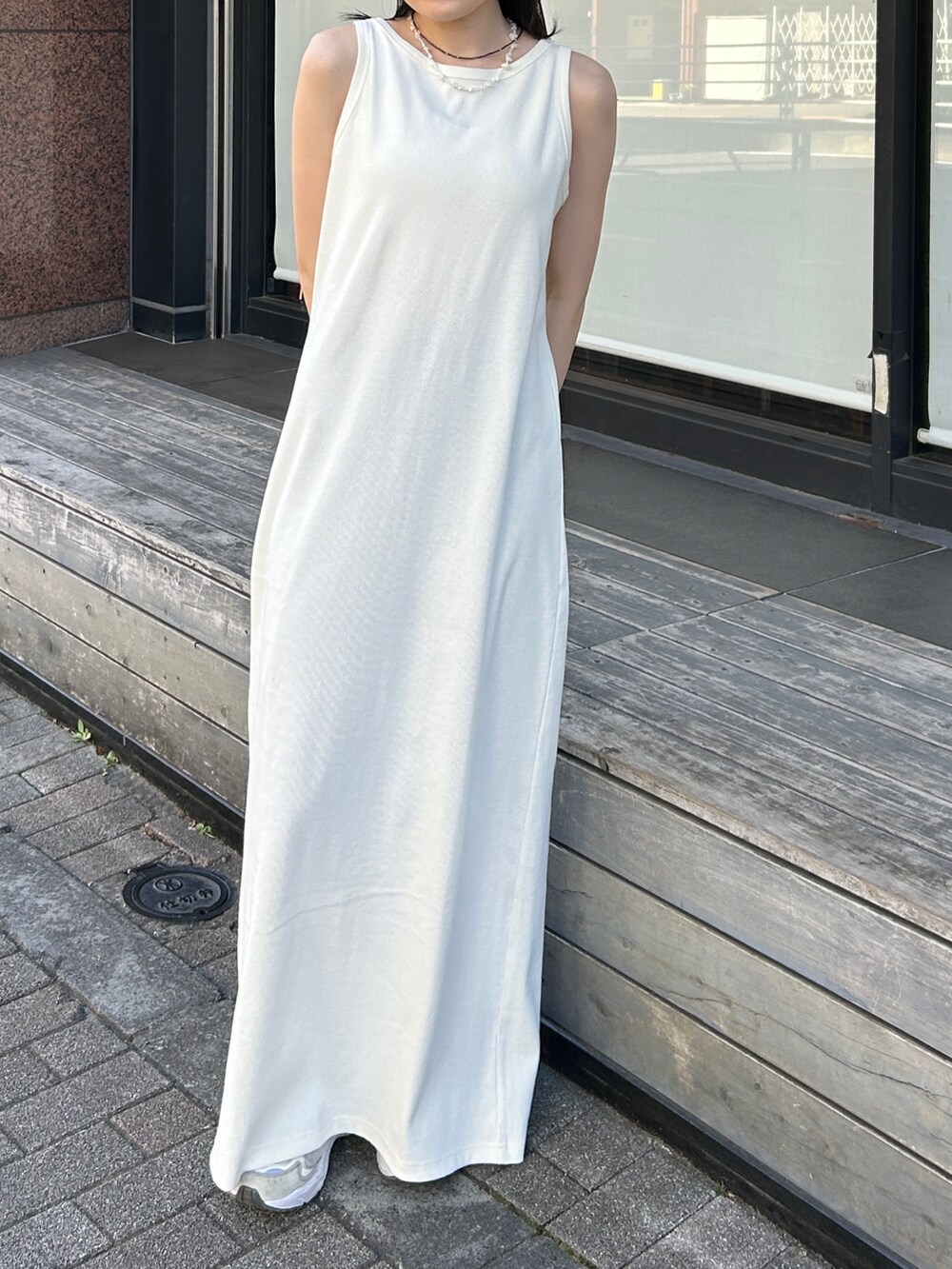 ホワイト系のワンピース、グレー系のカーディガン/ボレロ、ブルー系のネックレスを着用したレディースの夏コーディネートの2枚目の写真