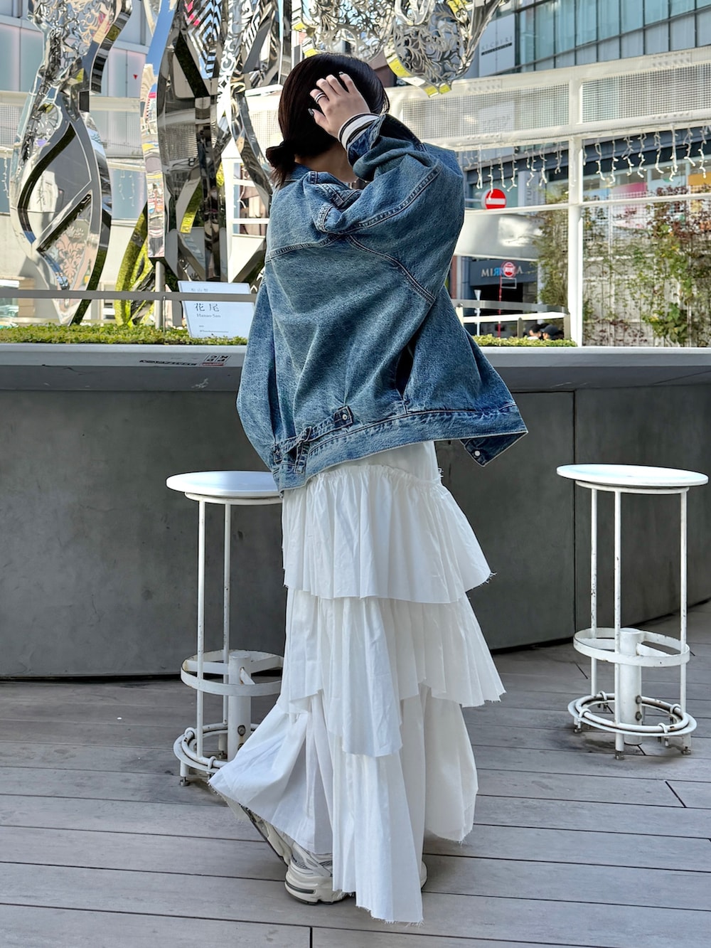 ホワイト系のスカート、ベージュ系のハンドバッグ、ブルー系のデニムジャケットを着用したレディースの冬コーディネートの5枚目の写真