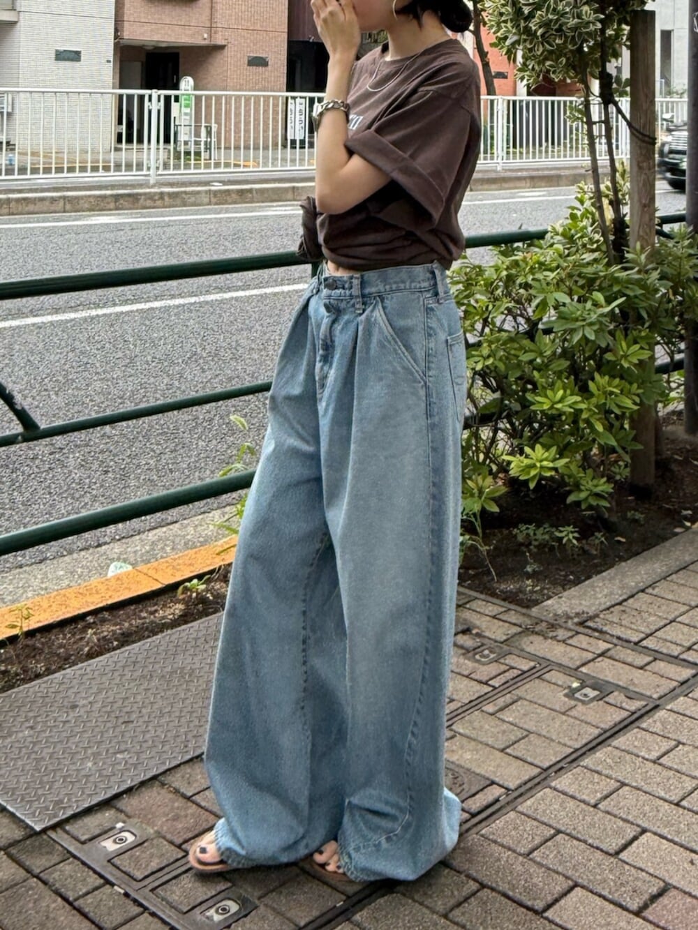 ブラック系のサンダル、ブルー系のデニムパンツ、ブラウン系のTシャツ/カットソーを着用したレディースの夏コーディネートの2枚目の写真