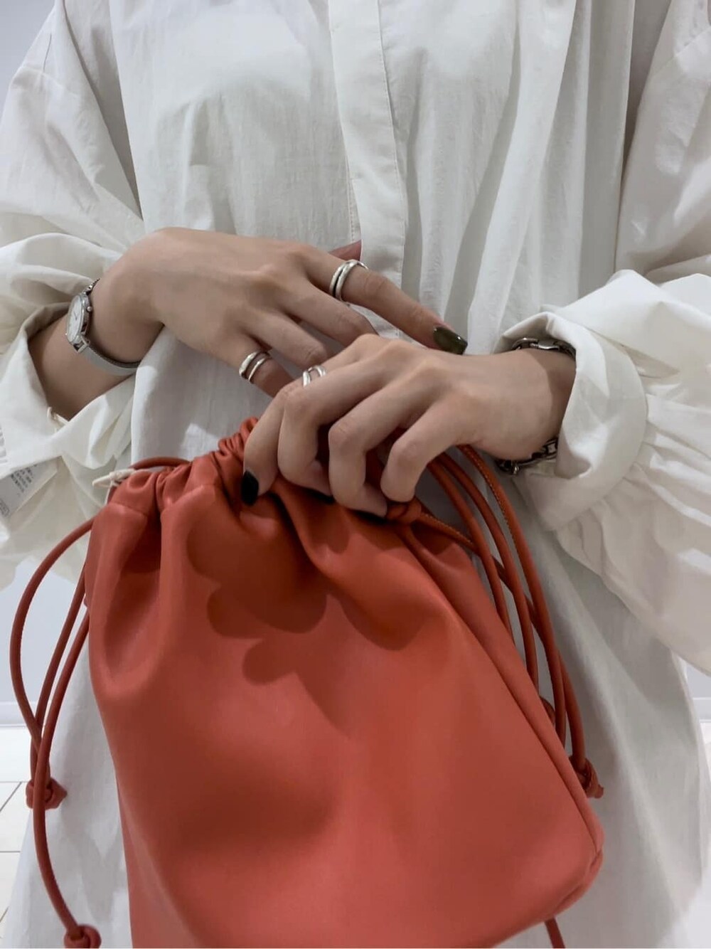 グレー系のスウェットパンツ、オレンジ系のハンドバッグ、ホワイト系のシャツ/ブラウスを着用したレディースの秋コーディネートの6枚目の写真